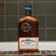 18.21 Man Made bottle in hand to show 18oz scale and travel-friendly convenience