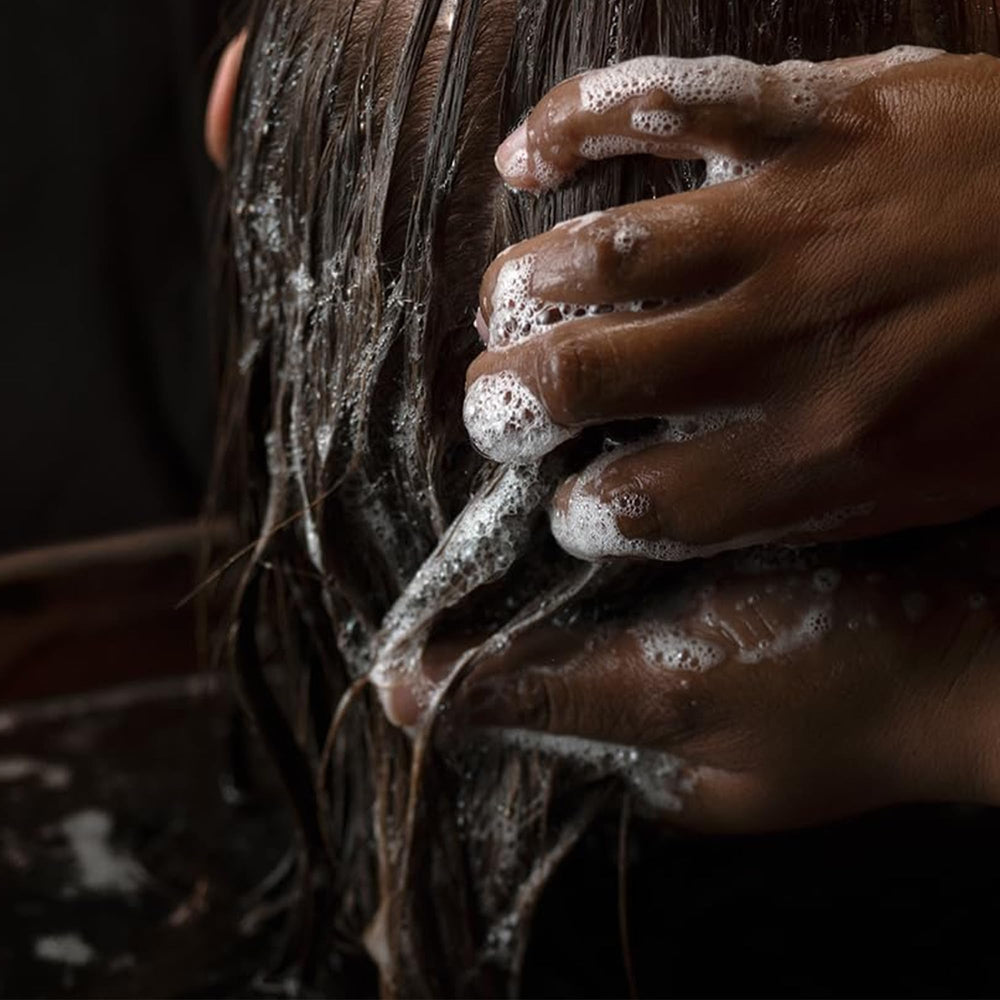 Aesop conditioner applied to hair strand showing detangling benefit