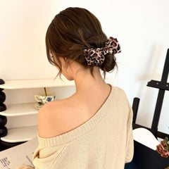 Auseibeely clip worn on a low bun adding instant cheetah-pattern charm