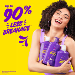 Applying Aussie Miracle Curls conditioner in shower to show hydration benefit