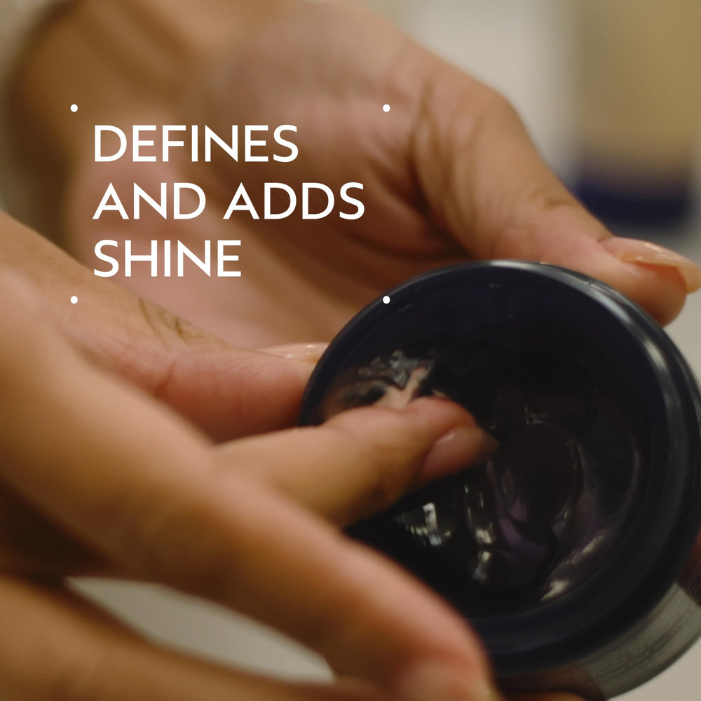Open jar texture of Aveda pomade highlighting creamy humectant finish