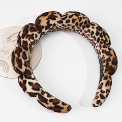 Ayesha headband next to ruler illustrating stretch size benefit