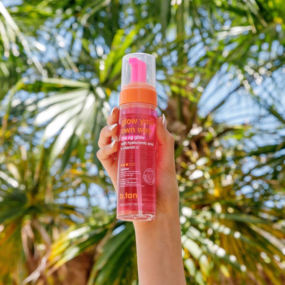B.TAN lifestyle image at beach radiating glowing skin and confidence benefit