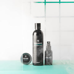 Ballsy Ballwash next to a toothbrush for scale showing compact 8 oz travel-friendly size