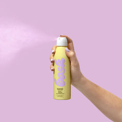 Bask sunscreen spray applied on beach for water-resistant protection
