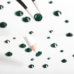 BEADSLAND rhinestones applied on a manicure adding bold emerald accents
