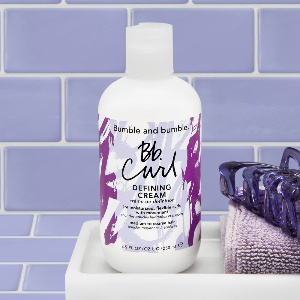 Bumble and bumble product beside hand for scale to show the 8.5 fl oz size