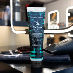 Bumble and bumble bottle staged with styled hair in lifestyle scene showing everyday use benefit