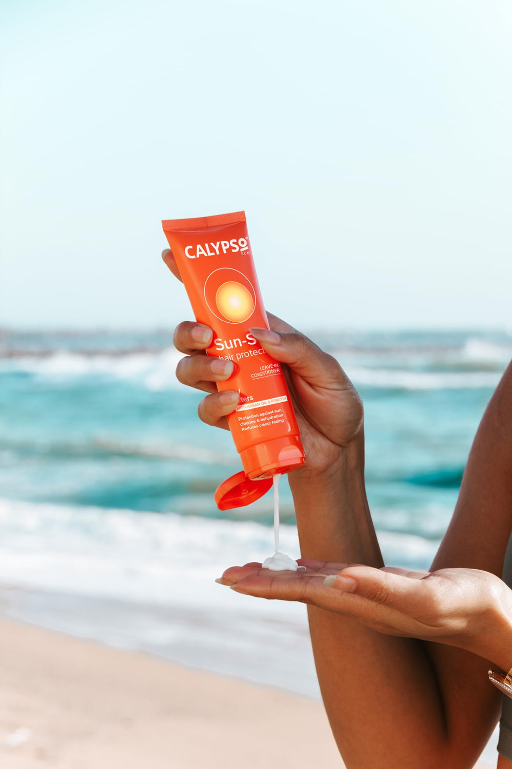 Calypso in a beach bag lifestyle shot conveying sun-ready hair care
