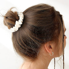 CEELGON scrunchie beside a coin for size scale highlighting compact, travel-ready design