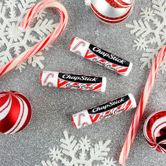ChapStick Candy Cane next to a coin showing compact travel size