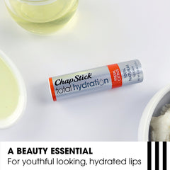 ChapStick next to a coin to show compact 0.12 oz size and portability