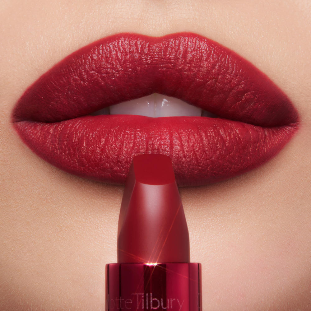 Charlotte Tilbury lip swatch on model highlighting bright cherry red vibrancy