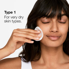 Hand applying Clinique Clarifying Lotion 1 with cotton pad demonstrating easy use