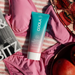 COOLA tube in beach lifestyle scene conveying outdoor-ready protection benefit