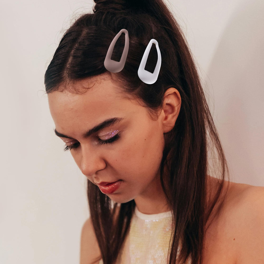 Cptots clip holding bangs in place on model, keeps hair tidy
