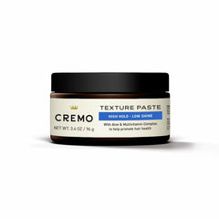 Cremo jar held in hand for scale, emphasizes travel-friendly size