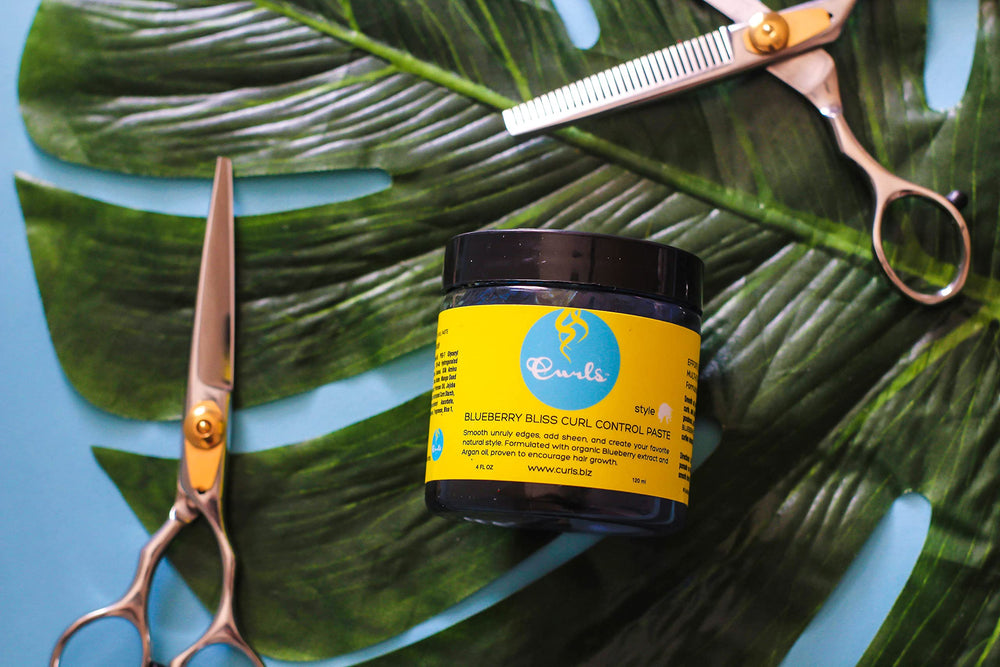 Curls Blueberry Bliss used to smooth edges on curly hair, showing defined, glossy finish