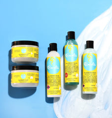 Curls bottle on vanity with styling tools conveying everyday use and curl-friendly routine