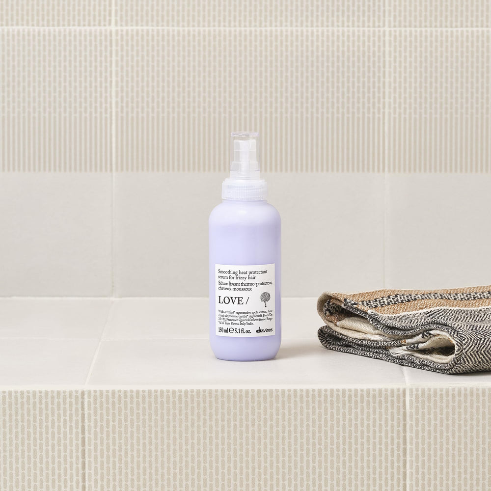 Applying Davines serum to hands demonstrating frizz control benefit