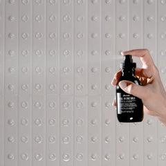 Hand holding Davines OI bottles to show true size and travel convenience