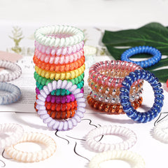 DealEachDay coil hair ties beside a ruler showing 2.17 and 2.5 inch diameters, clear sizing benefit