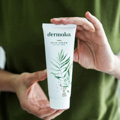 Dermaka 4 oz jar held against hand showing real size for travel-friendly use