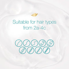 Dove shampoo in shower being applied to textured hair to demonstrate in-use hydration