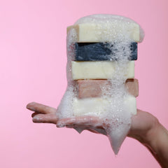 Dr. Natural bar next to a hand to show actual product size and scale