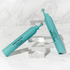 Applying Eight Saints serum under eye with roller to reduce puffiness visibly