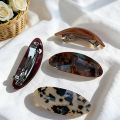 ELLOPH barrette beside a hand for scale to show large size and comfortable grip