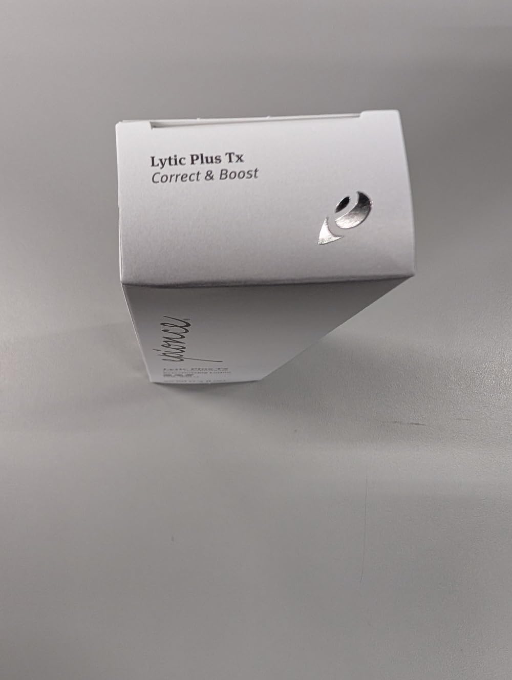 Epionce Lytic Tx beside a coin to show bottle size and travel-friendly scale