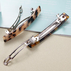 Eyegla gift box open with two barrettes neatly presented, ready for gifting