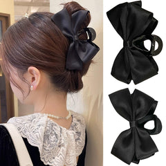 FDBJulyy front view of two black bow clips showing shape and finish for versatile styling