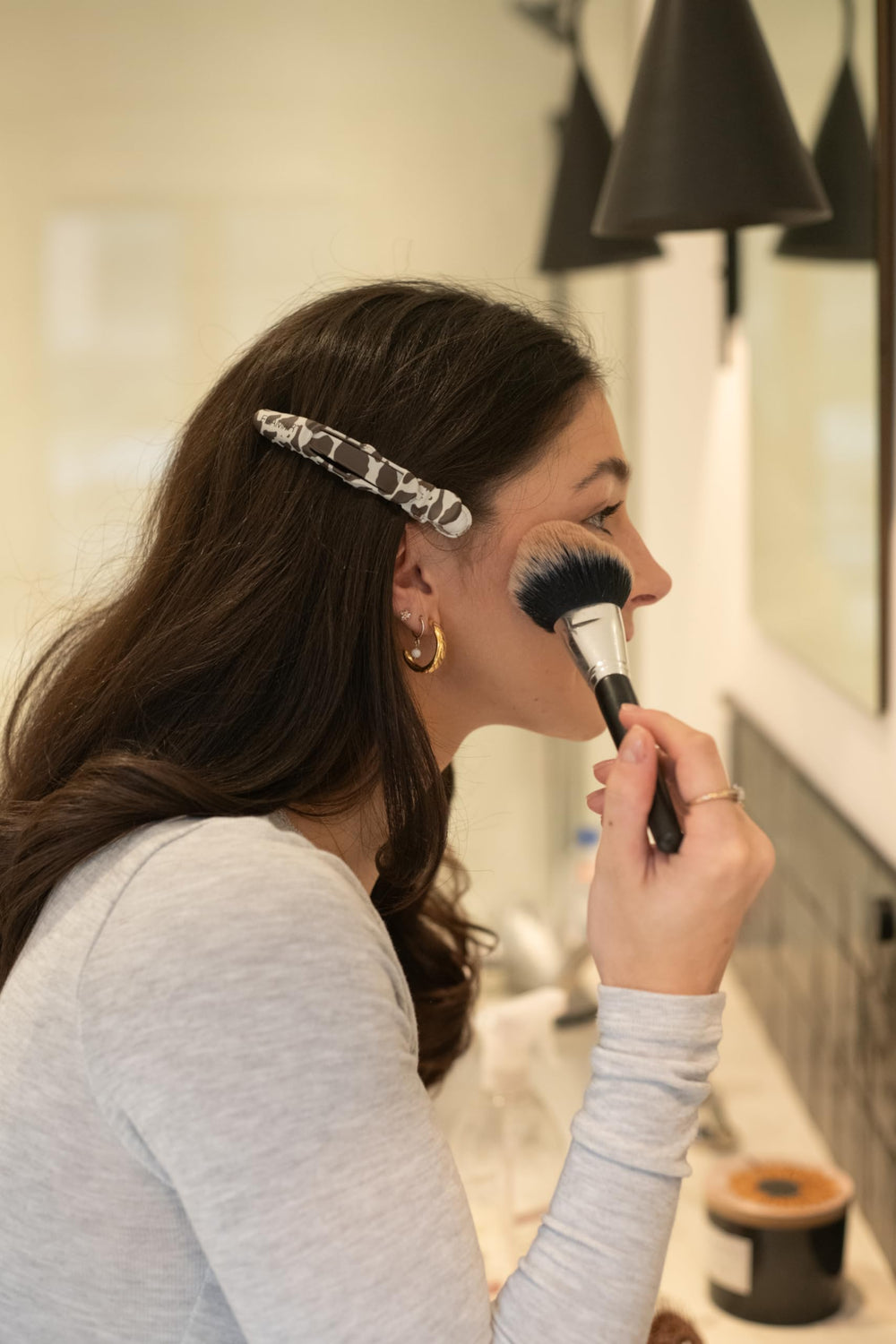 FRAMAR clip held beside a hand showing size and easy handling for stylists