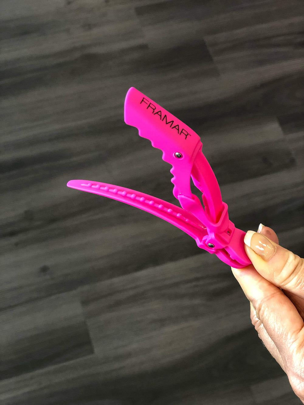 FRAMAR clip in hand showing size and scale for portability benefit