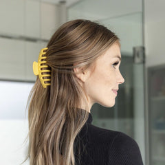FRAMAR clip opened wide holding a large hair section illustrating capacity and ease
