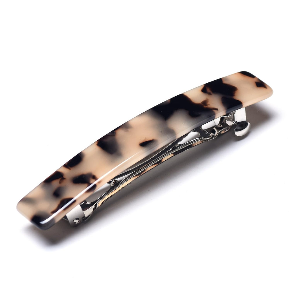 Fsmiling woman outdoors wearing barrette, conveys versatile everyday style