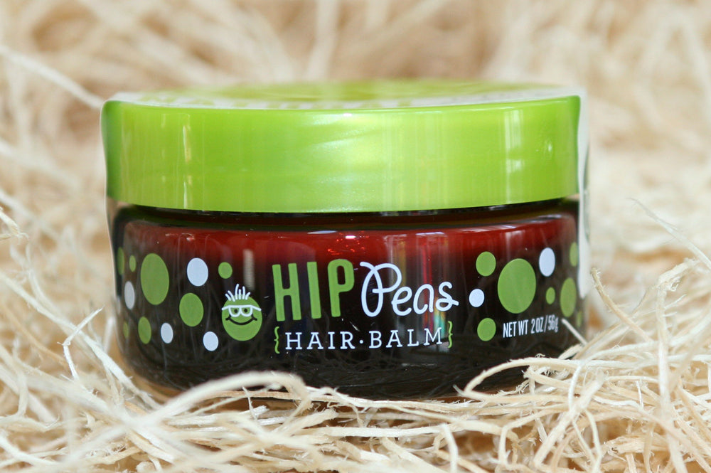 Parent applying Hip Peas balm to child hair to tame flyaways gently