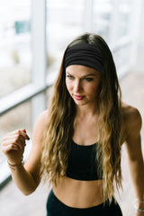 Huachi headband stretched across a hand showing fit range and elastic hold benefit