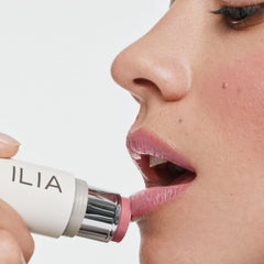 ILIA applying multi‑stick to cheek in lifestyle scene for quick touchups