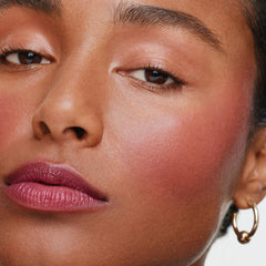 ILIA multi-stick being blended on cheek for natural blush finish