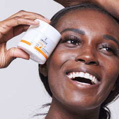 IMAGE Skincare jar on nightstand styled with candle showing nightly routine and calming benefit