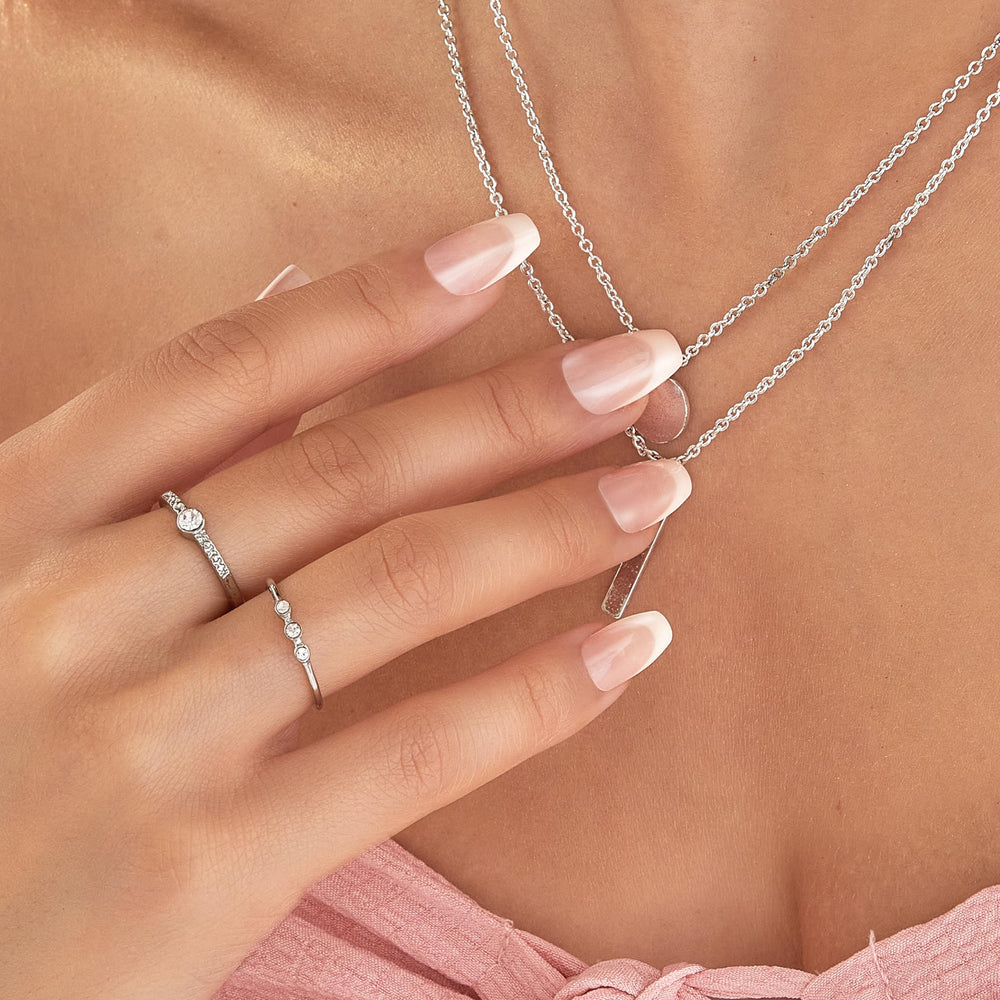 imPRESS nails on fingers beside coin for scale demonstrating medium coffin length