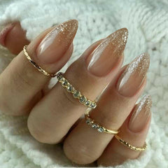 IQXGE close-up of gold glitter accent on nail, highlighting sparkly decorative detail