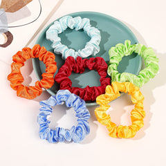 Ivyu scrunchie next to coin showing small compact size for travel