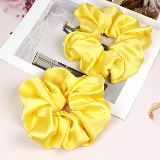 JGQUR front-packaging showing two yellow satin scrunchies and product benefits