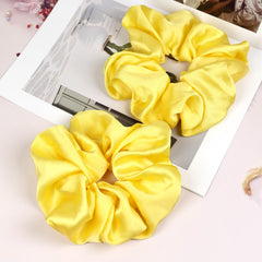 JGQUR front-packaging showing two yellow satin scrunchies and product benefits