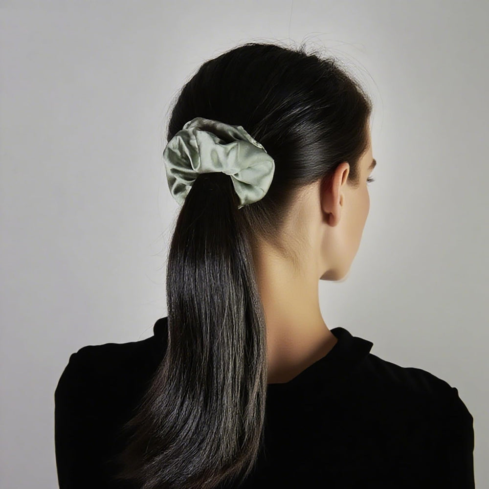 JGQUR hand holding clips and scrunchies to show scale and travel-friendly size