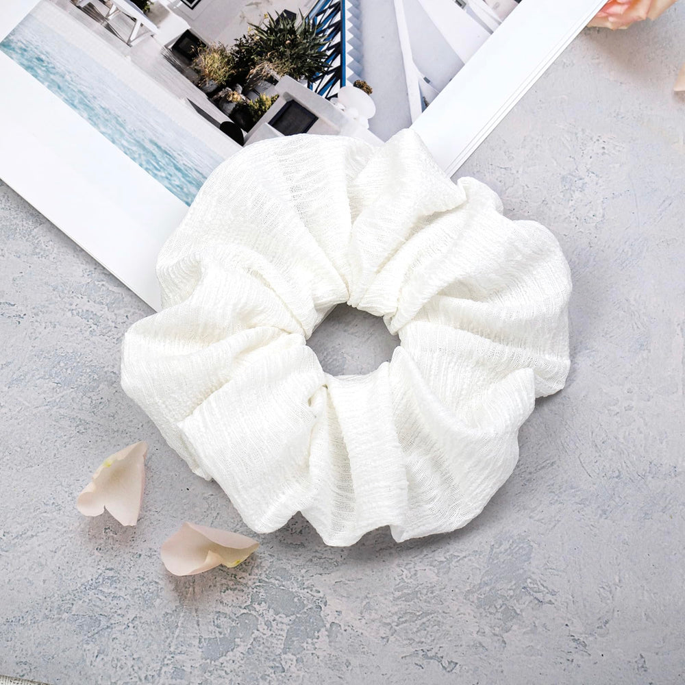 JGQUR scrunchie next to a coin for size scale and fit reference